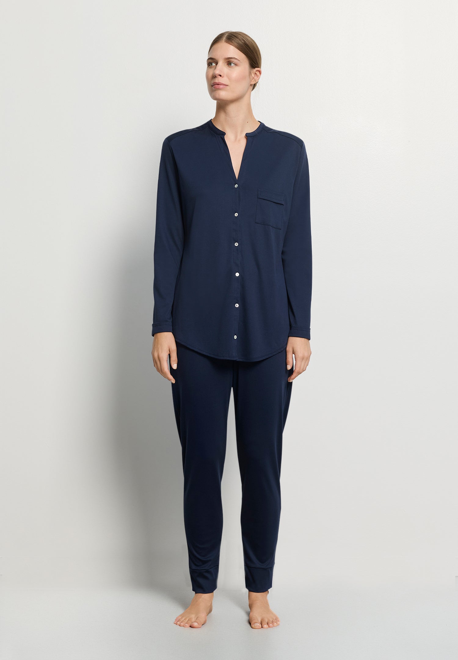 Person wearing navy blue pajamas on a light gray background