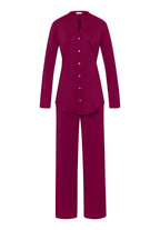 A long sleeve cotton pajama set with a button front and mother-of-pearl buttons, in a deep poppy red color, including a top with a chest pocket and full-length pants with a covered elastic waistband.