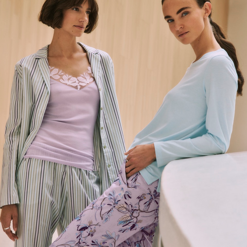Two women wearing pajama sets in a casual setting.