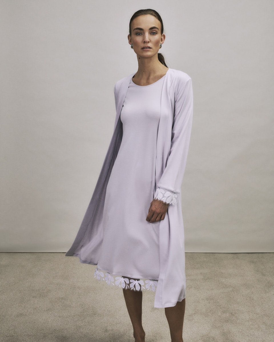 Woman wearing a Kalea light purple nightgown with a matching robe against a plain background