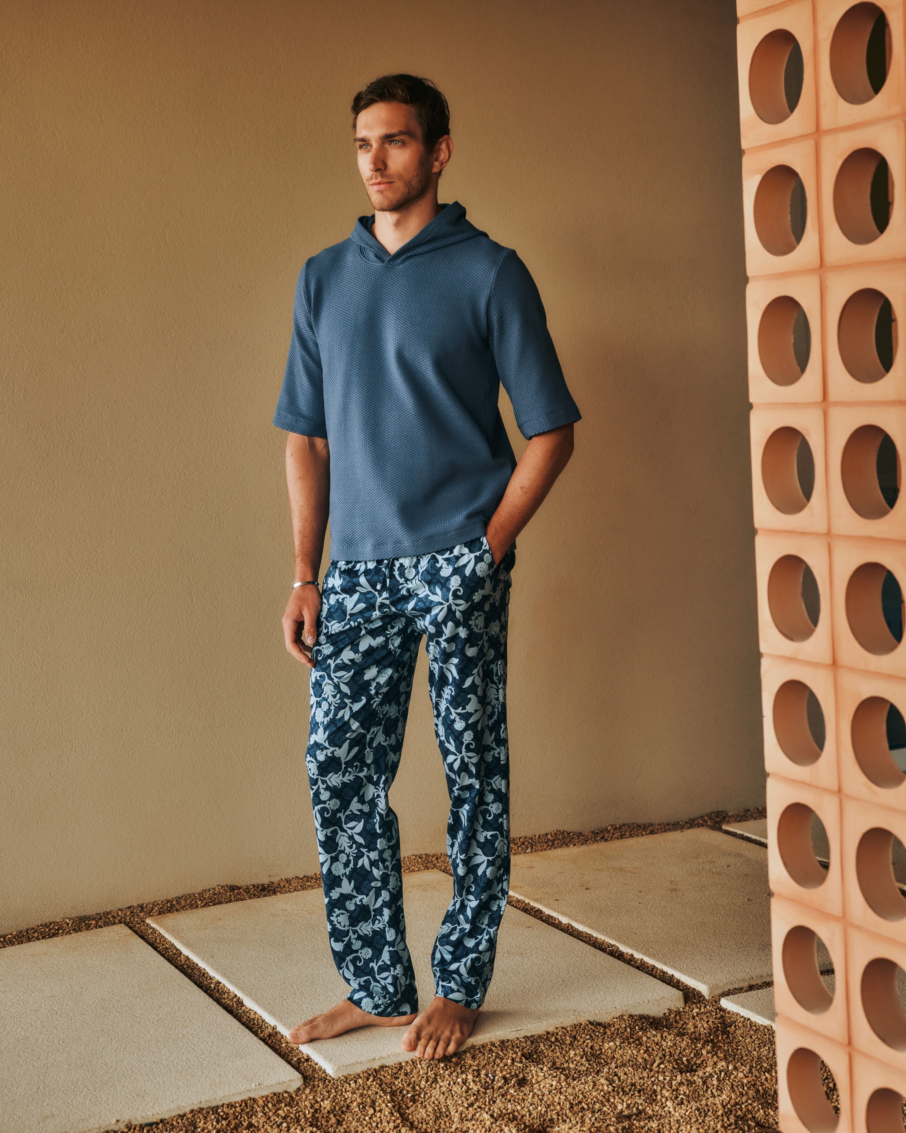 Man standing outside with his hand in his pocket, wearing the Smartwear Short Sleeve Hoodie paired with Night and Day Pants in Night Blue Tile.