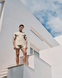 Man standing on a modern architectural structure with a clear sky background