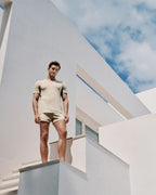 Man standing on a modern architectural structure with a clear sky background