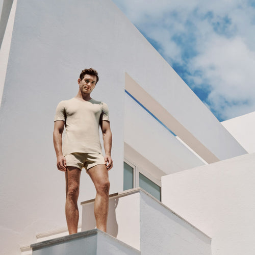 Man standing on a modern architectural structure with a clear sky background