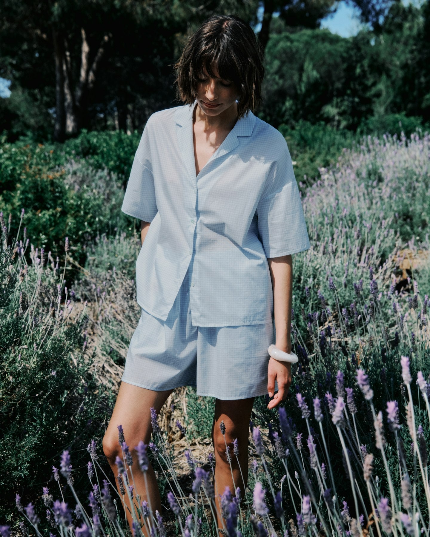 Person wearing a light blue outfit standing in a lavender field