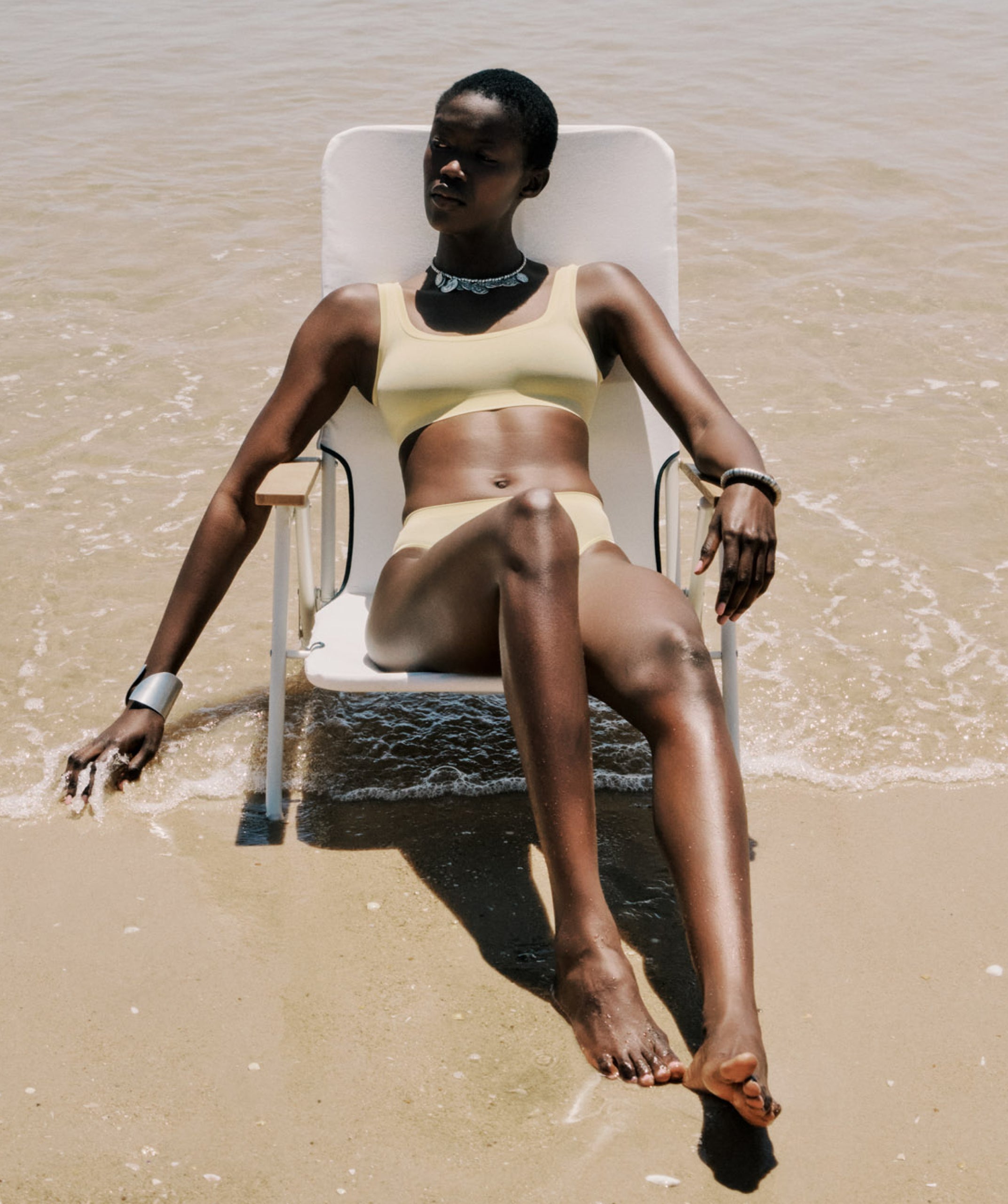 woman model wearing Touch Feeling crop top and briefs sitting on the beach
