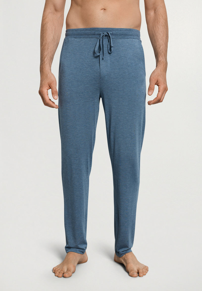 Man wearing blue pajama pants on a white background
