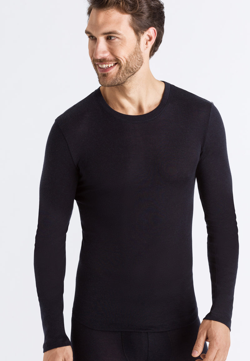 Man wearing a black long-sleeve shirt against a white background