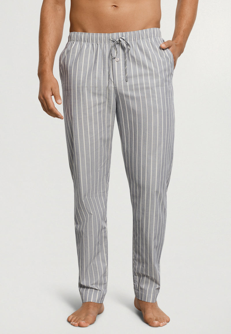 Man wearing gray striped pajama pants on a white background