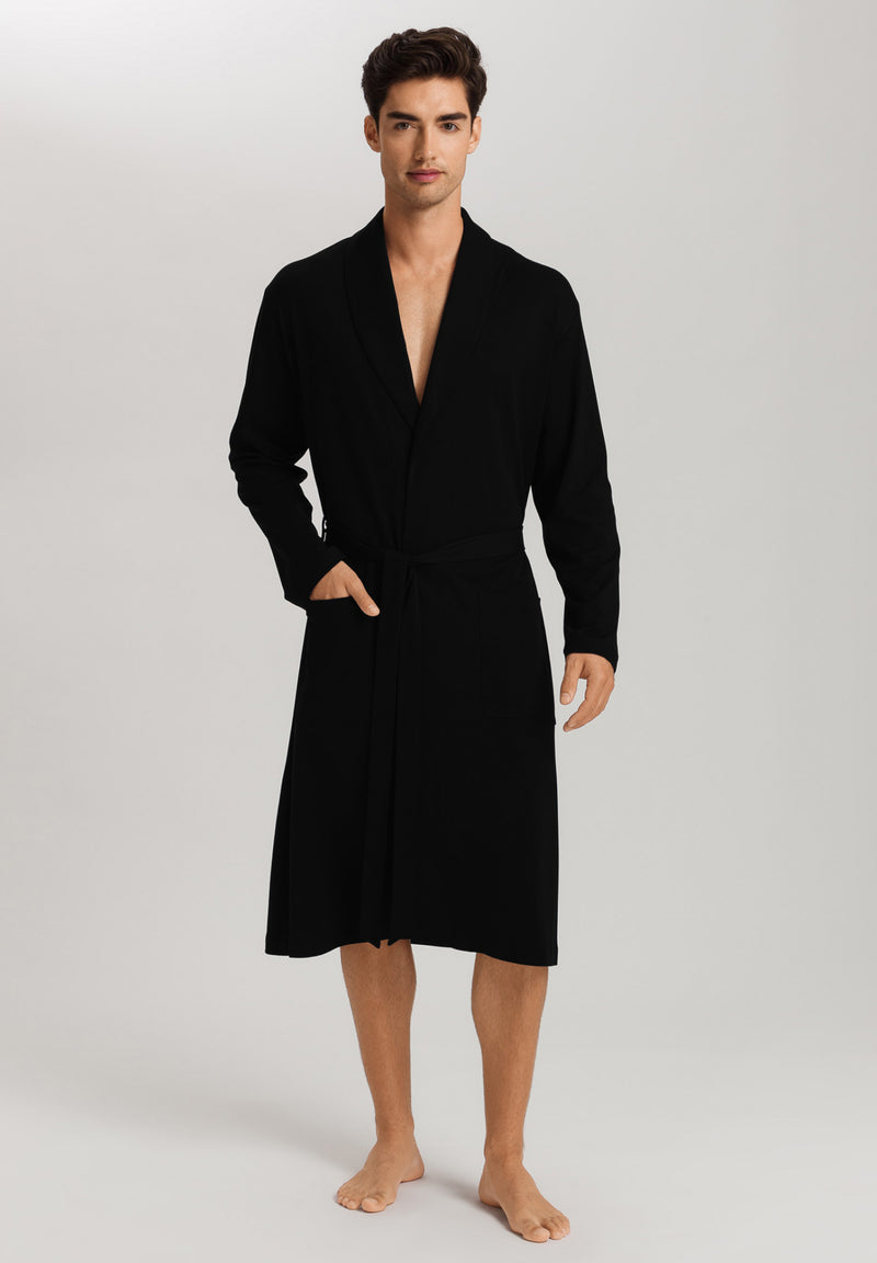 Man wearing a black robe on a plain background