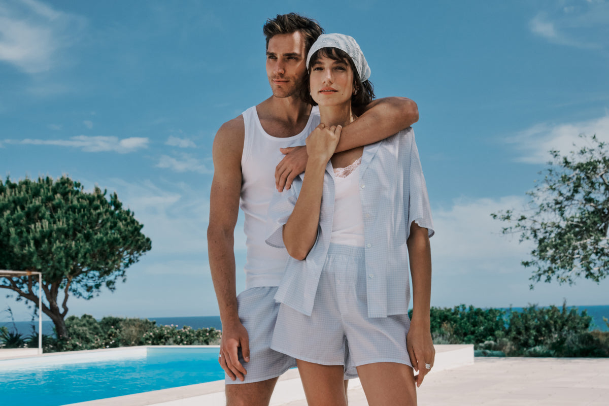 Couple standing by a pool with a scenic background